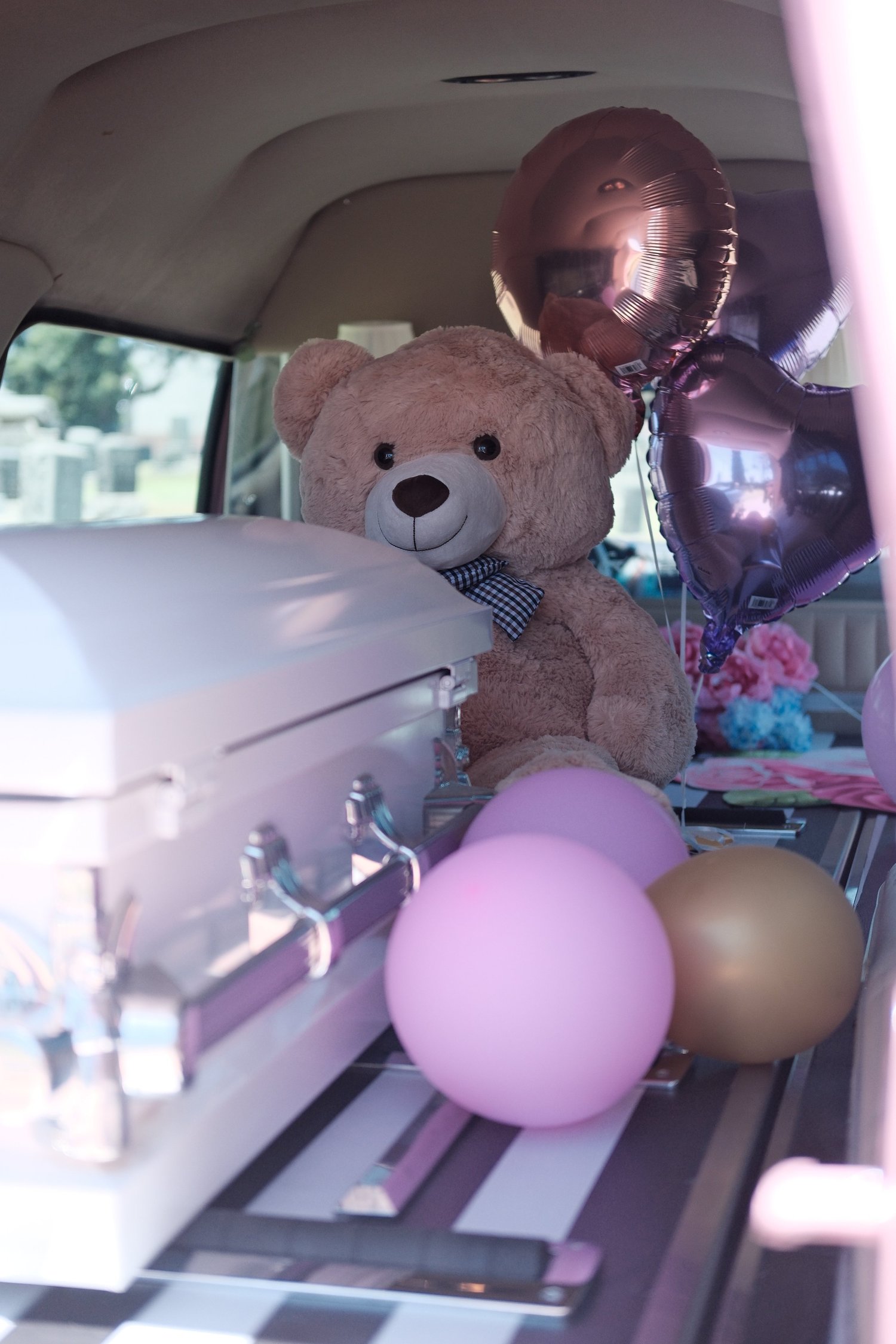 The hearse interior decorated with balloons and a teddy bear