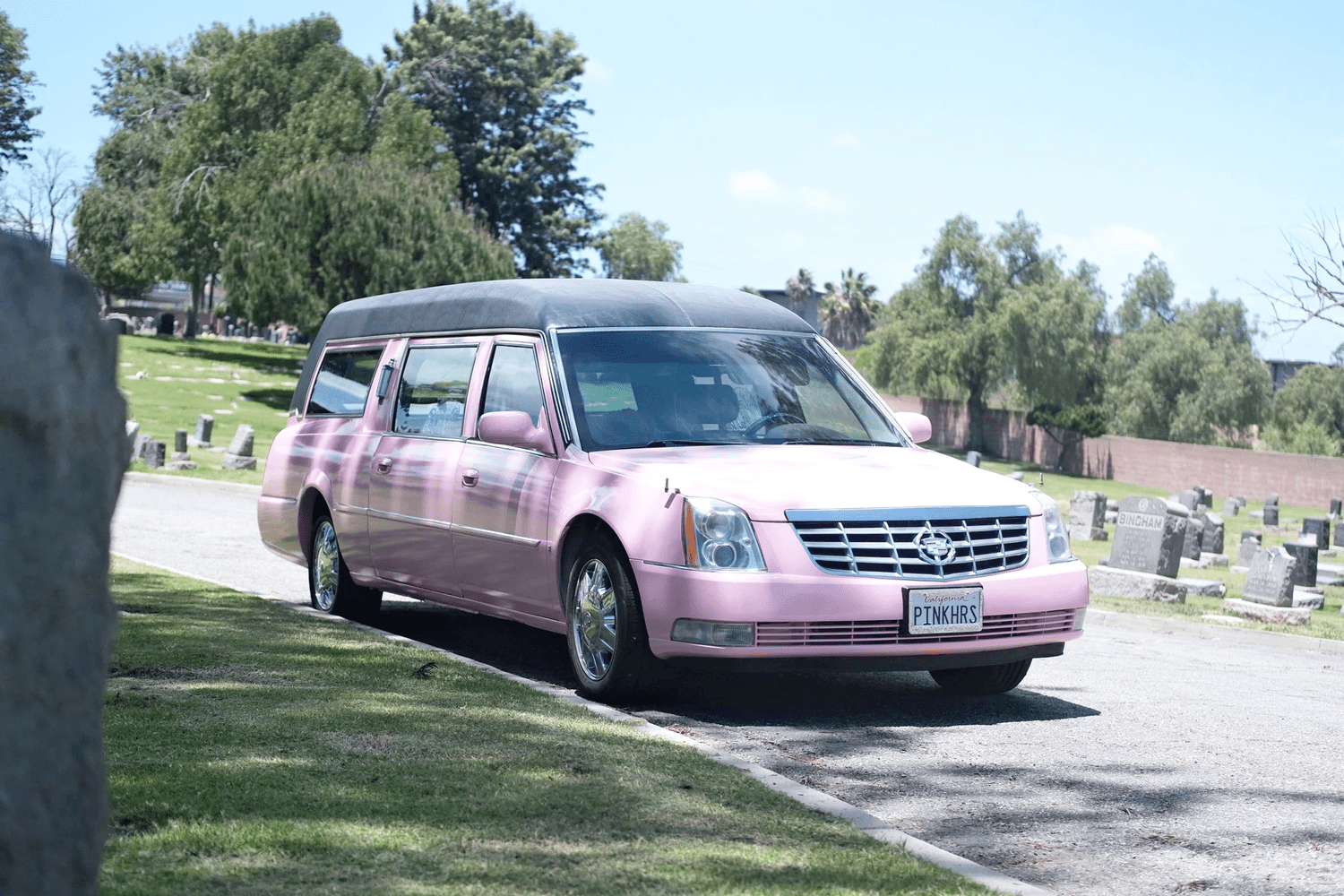 Hearsula, the pink hearse, on a quiet cemetery lane