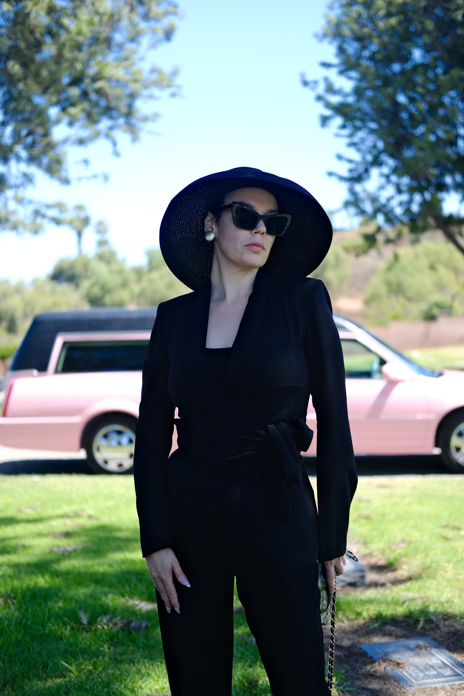 Sara, founder of The Pink Hearse, beside the pink hearse